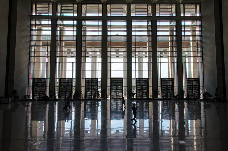 inside the front entrance to the National Museum of China, large columns in front of tall windows reflect on a marble floor (photograph by Scott Gunn)